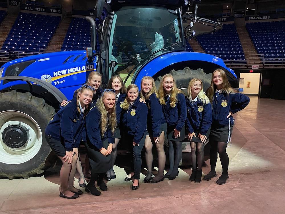 group of young women in front of New Holland tractor