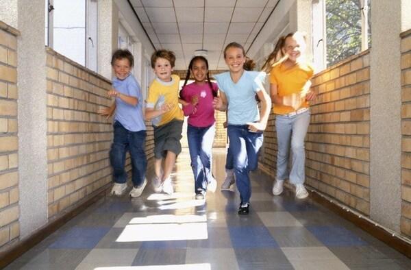 Children running down a hall in a school.