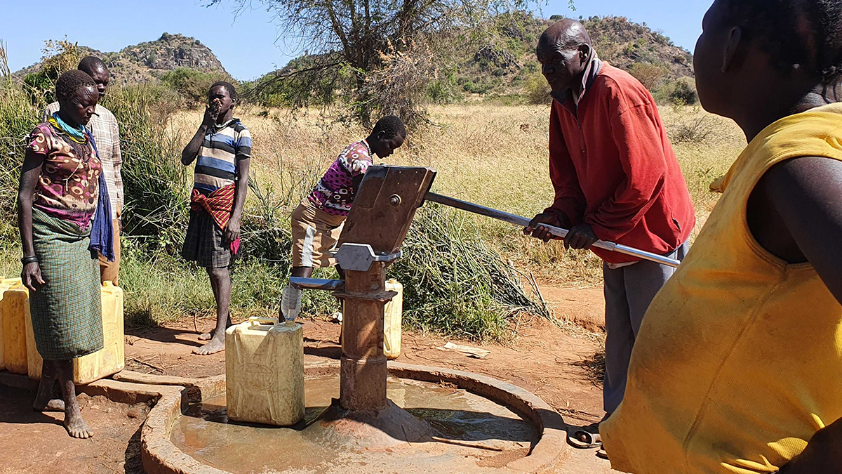 People installing the India Mark II on a village hand pump