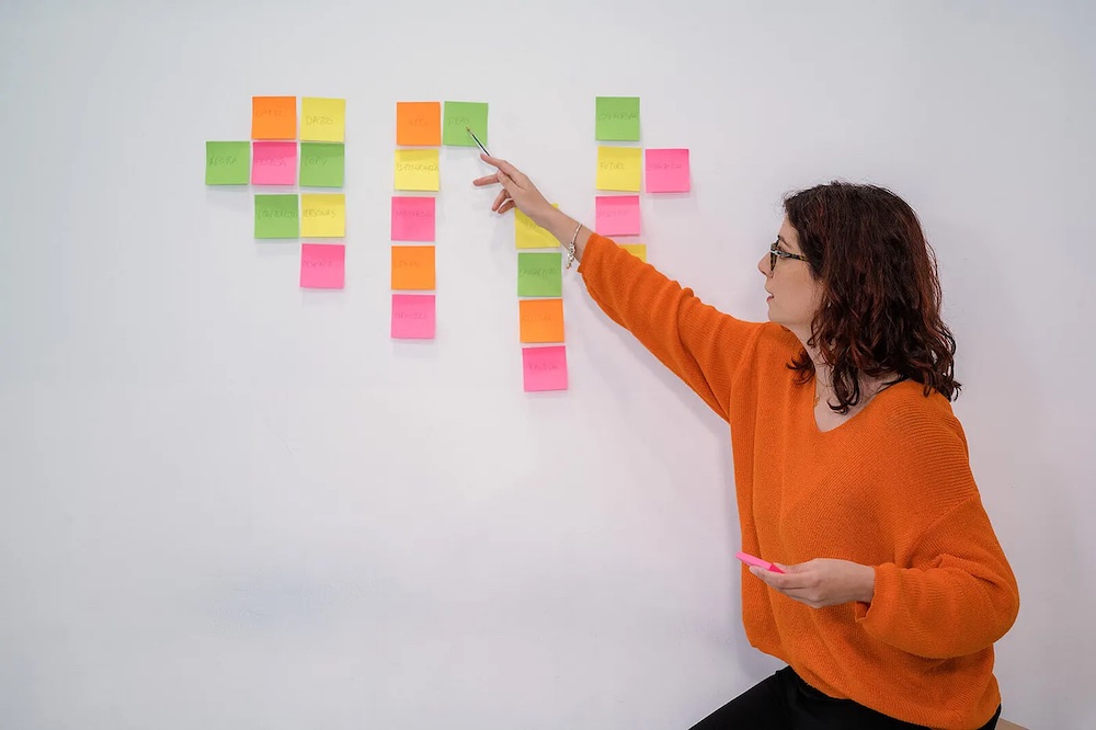 Clara Avila in front of a wall with colored post it notes.