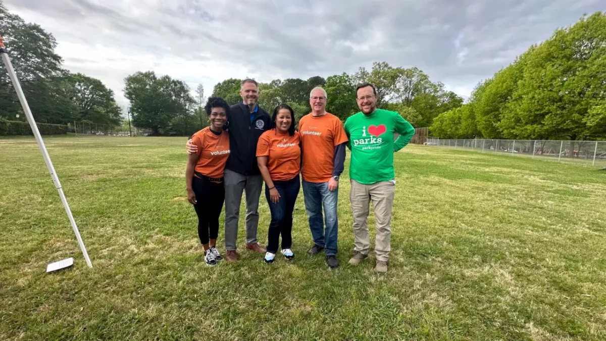 A group of volunteers stood together in a field smiling