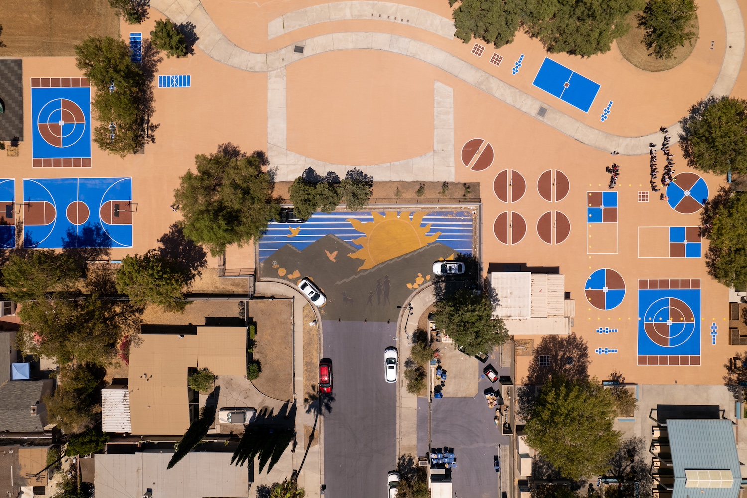 A birds-eye view of a multi-colored, cool-pavement-coated park. 