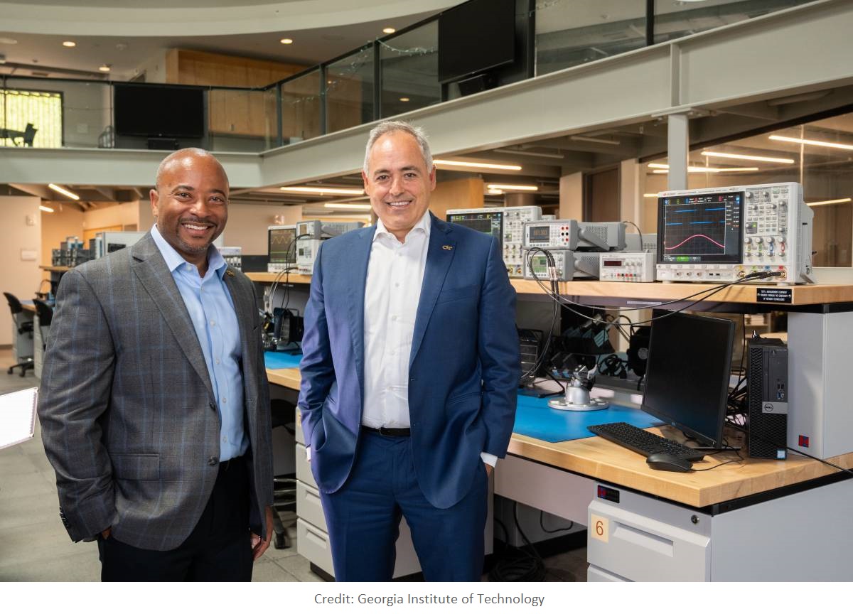 Two men standing in front of a lot of technology 