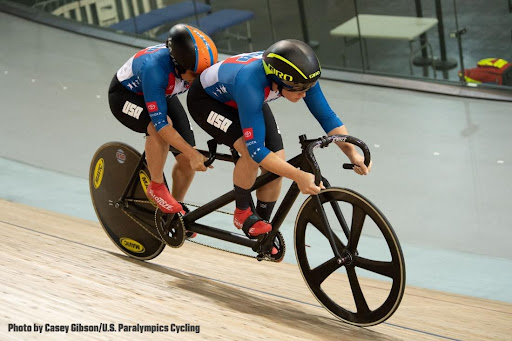 MK Wintz, front, pilots a tandem bike ahead of riding partner Hannah Chadwick, who is visually impaired and rides in the back “stroker” position. MK, who does not have a physical impairment, helps guide the bike through the track.