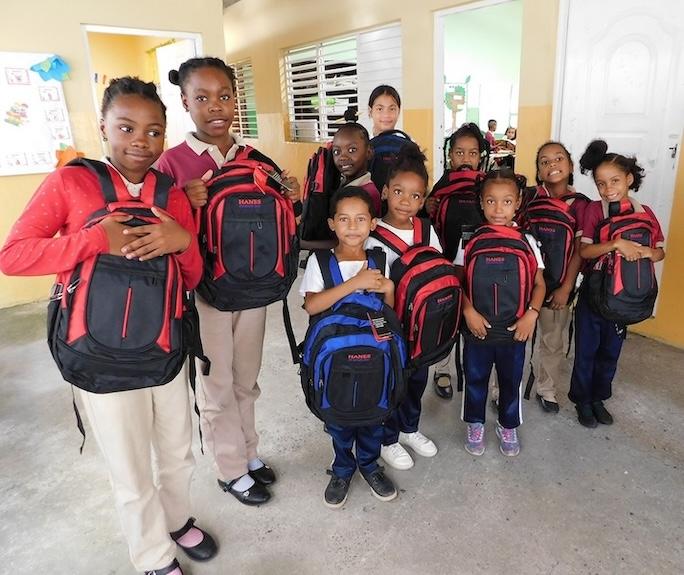 Group of young school children shown with their new HanesBrands backpacks for Back to School.
