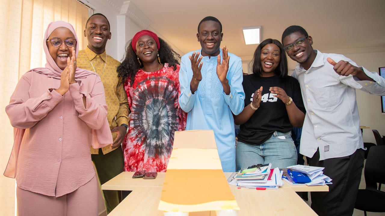 Group of six smiling, clapping people
