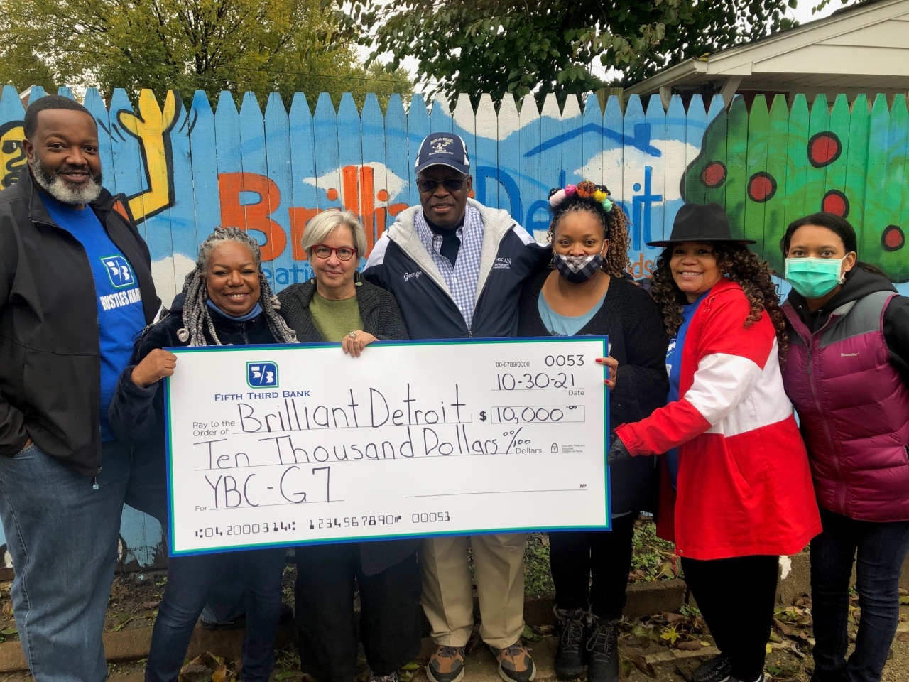 Members of Brilliant Detroit holding $10,000 check from Fifth Third Bank