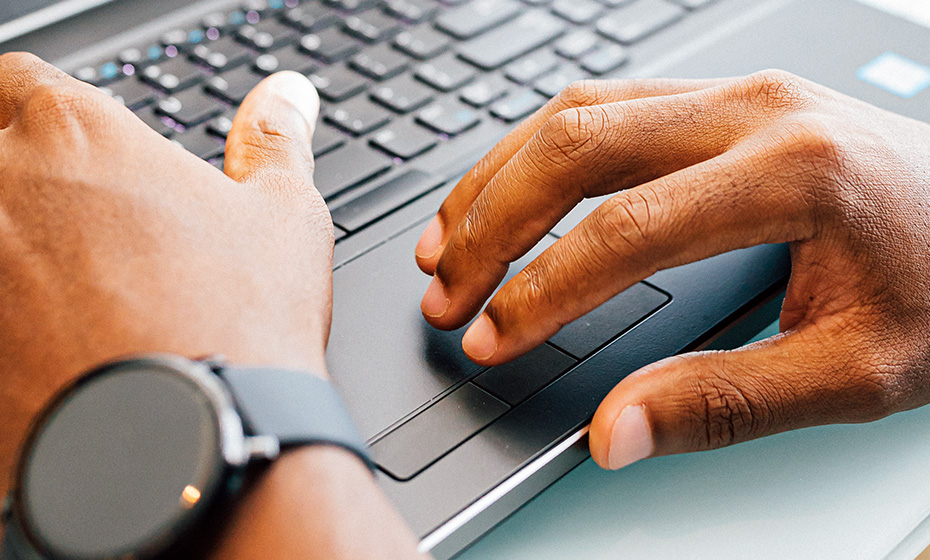 person's hands working on a laptop