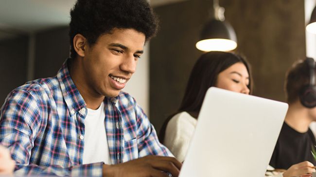 person smiling at laptop