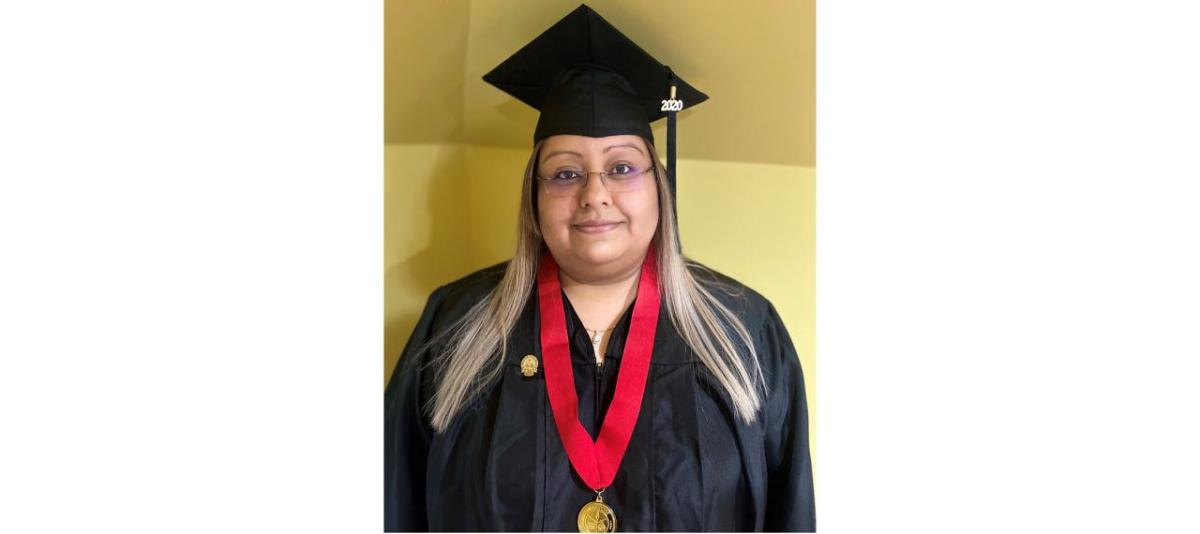 Elizabeth Arroyo Gomez stood smiling in a graduation cap and gown