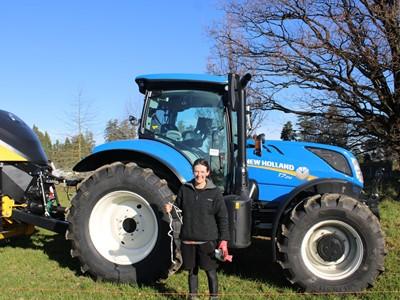 Emma Poole in front of a New Holland tractor.