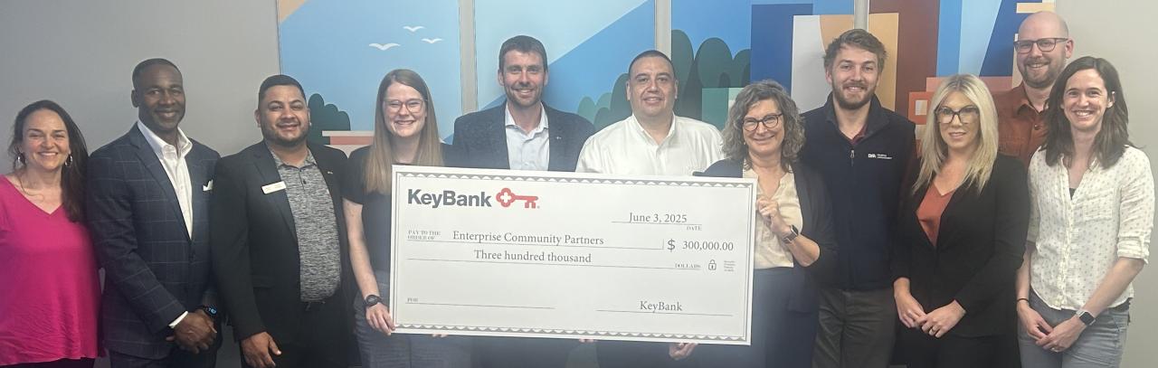 Representatives from KeyBank and Enterprise Community Partners shown with a grant check for $300,000.