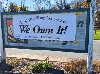 Evergreen Village Cooperative banner: "We Own It".