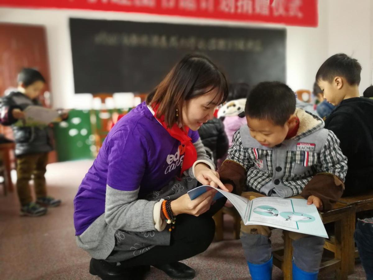 teacher looking at a book with child