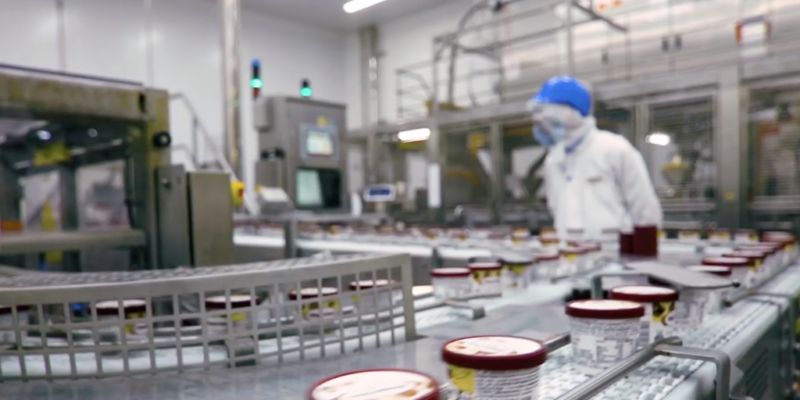 A worker in protective gear monitoring a Häagen-Dazs factory