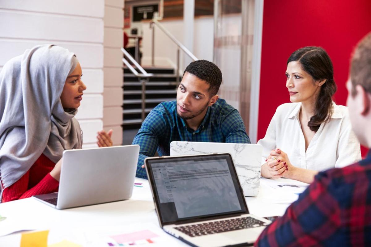 students gathered around a table in conversation