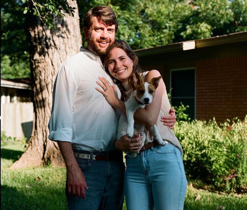 Clement, his wife and their dog in a yard.