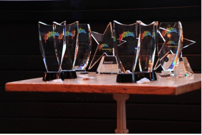 Golden Bridge Award trophies on a small table