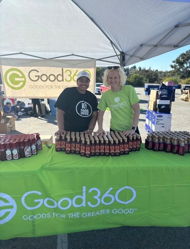 Two people standing at the Good360 booth