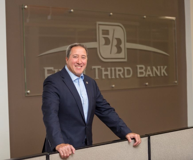 Greg Carmichael in front of Fifth Third Bank sign