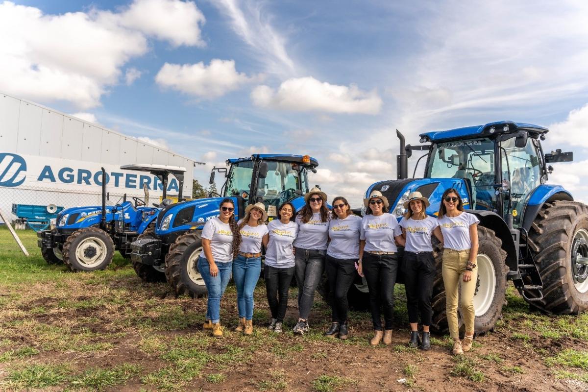 A group of women stood in front of some tractors 