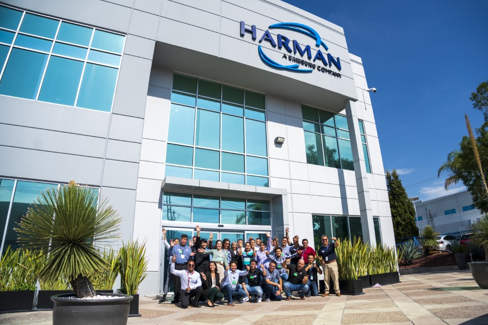 Outside of the HARMAN factory. HARMAN team shown in front of the building.