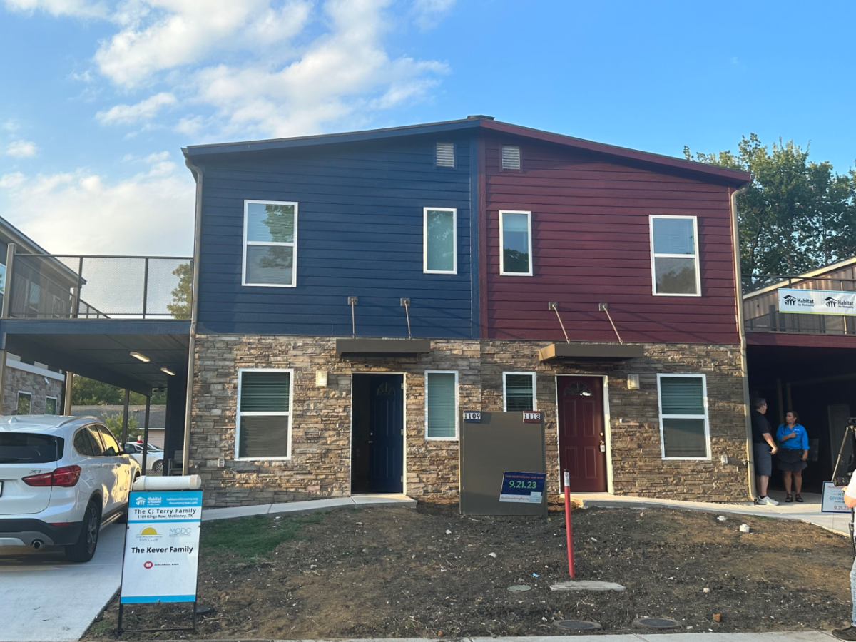 Blue shipping container house on left, burgundy shipping container house on right