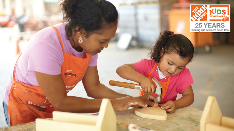 The Home Depot volunteer helping a child with a woodworking project.