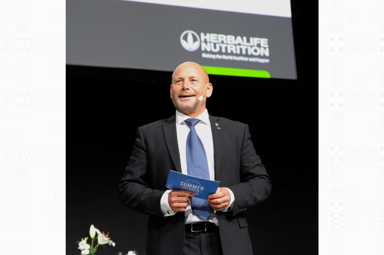 A person standing on a stage holding a blue card. "The plant-based diet" Logo behind.