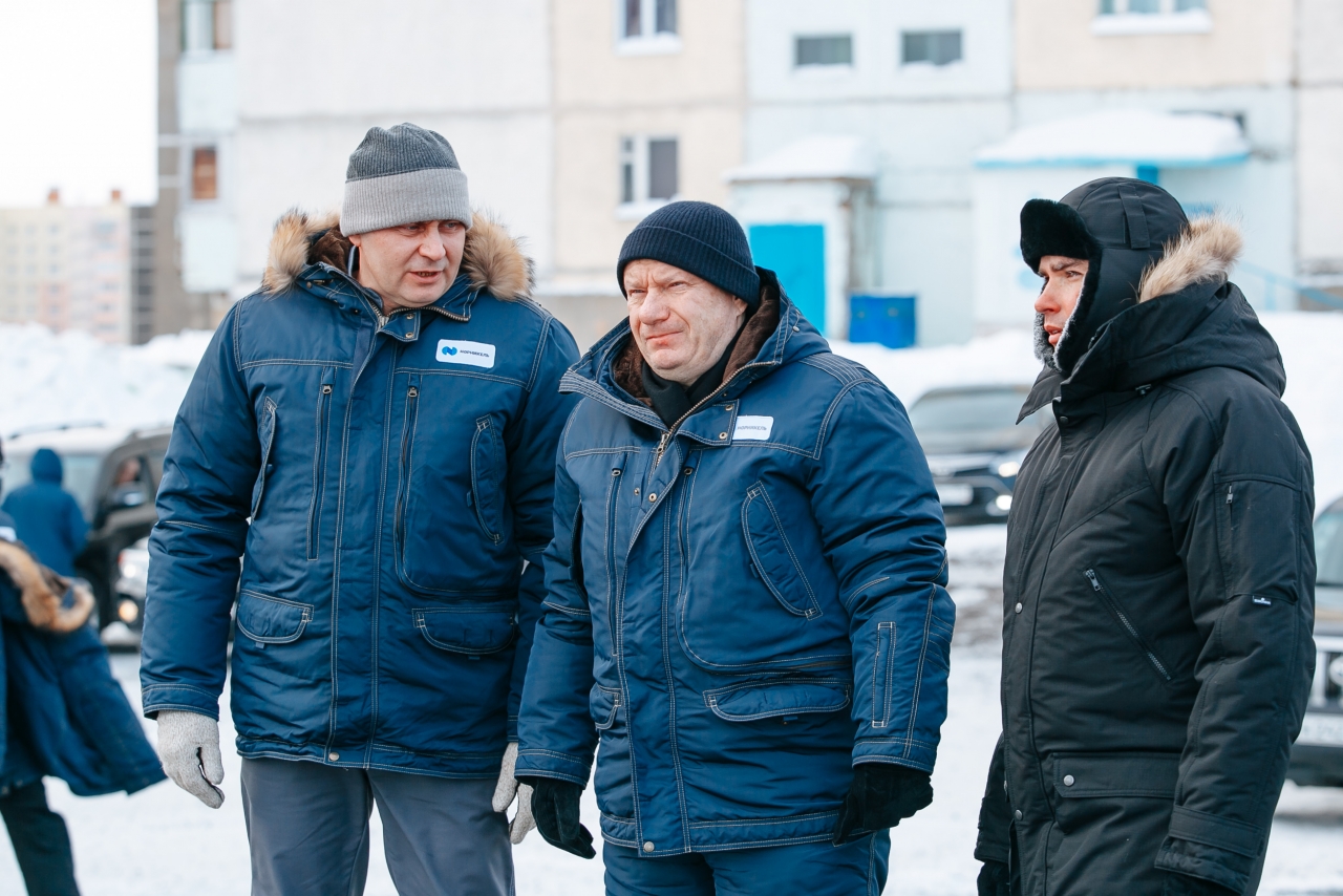 Image of three men wearing parkas