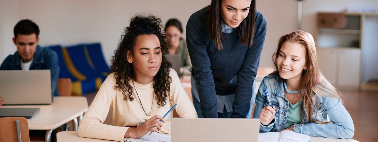 3 women looking at an open laptop