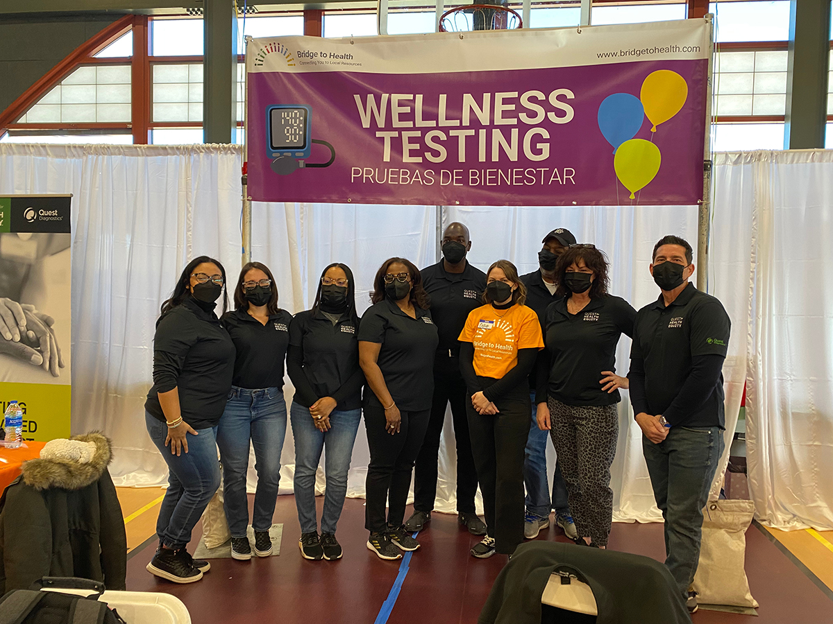 group of people under a banner sayi400ng "wellness testing"