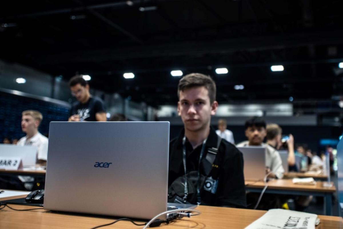 A participant with Acer laptop at IOI 2023