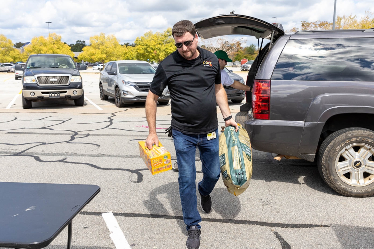 a person unloading supplies from the back of a car