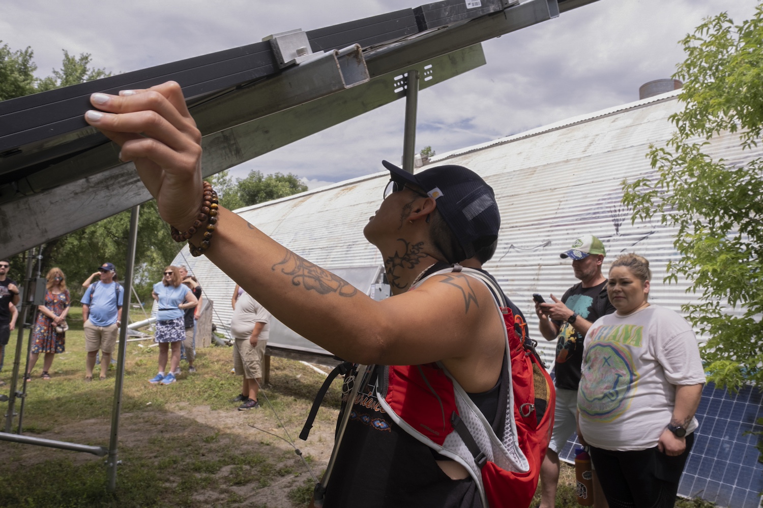 Charlee Rising Sun examining a solar panel array. 