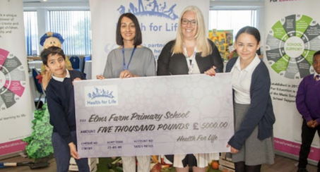 Students and teachers holding a cheque 