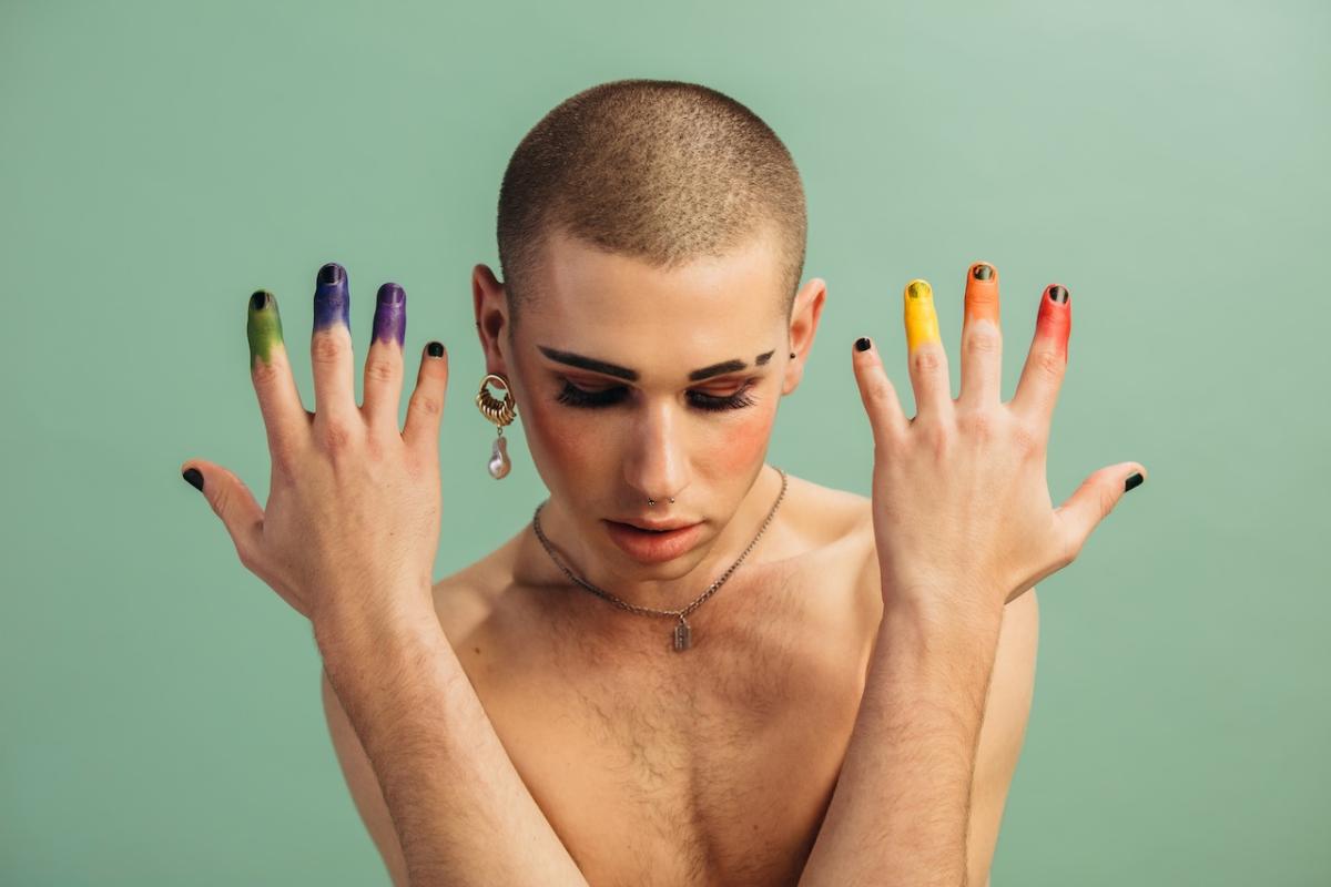 Person shown with rainbow colored fingers.