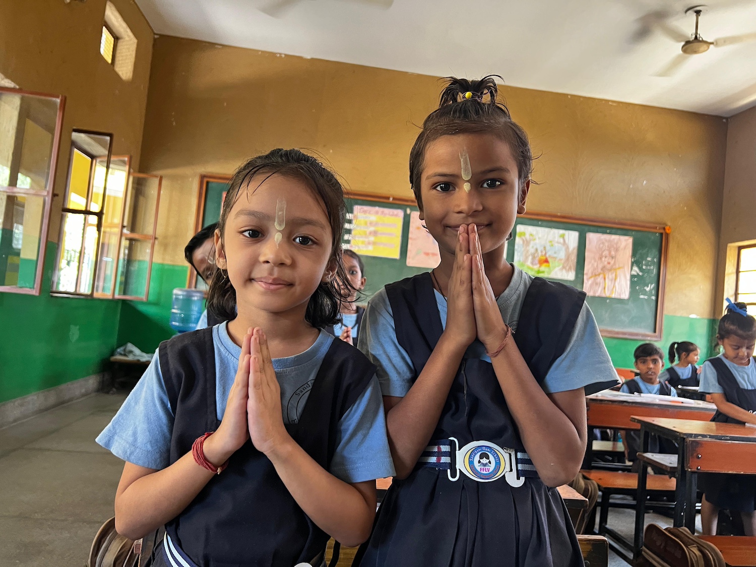 Two students in a Commit2Change classroom classroom in Vrindavan, India — International Day of the Girl