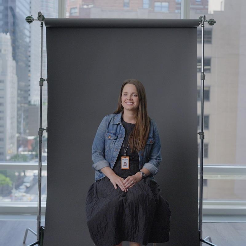 Photo of Jacquie Lennon sat in front of a grey backdrop