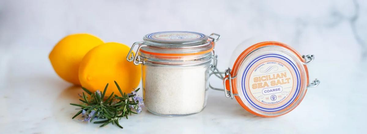 Sicilian Sea Salt shown in it's container and with lemons.