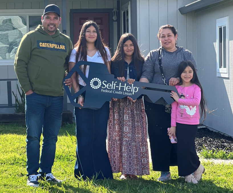 Family posing with giant key