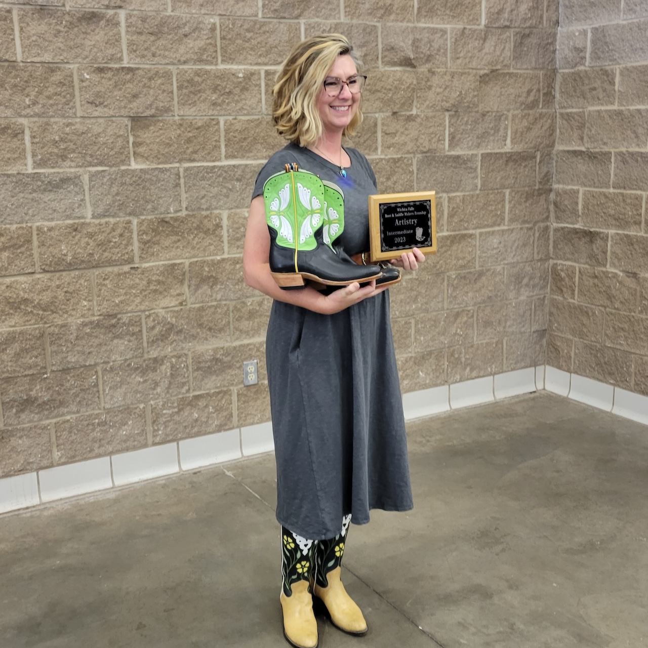 Kelly Howell, owner of Dragonfly Ink Designs, accepting the 2023 Artistry Award for Intermediate Bootmakers at the Wichita Falls Boot and Saddle Show.
