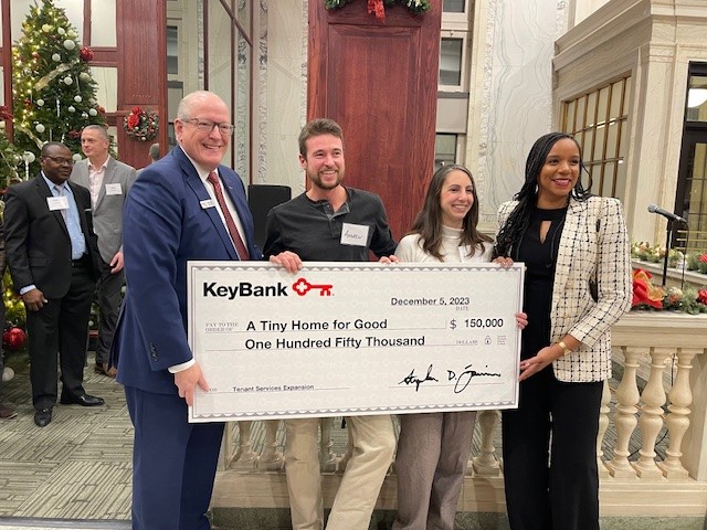KeyBank and A Tiny Home for Good representatives hold a grant check for $150,000.