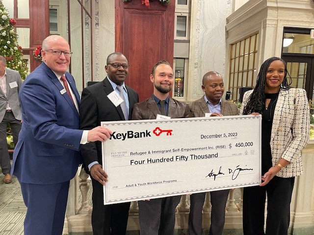 KeyBank and representatives from RISE holding a $450,000 grant check.
