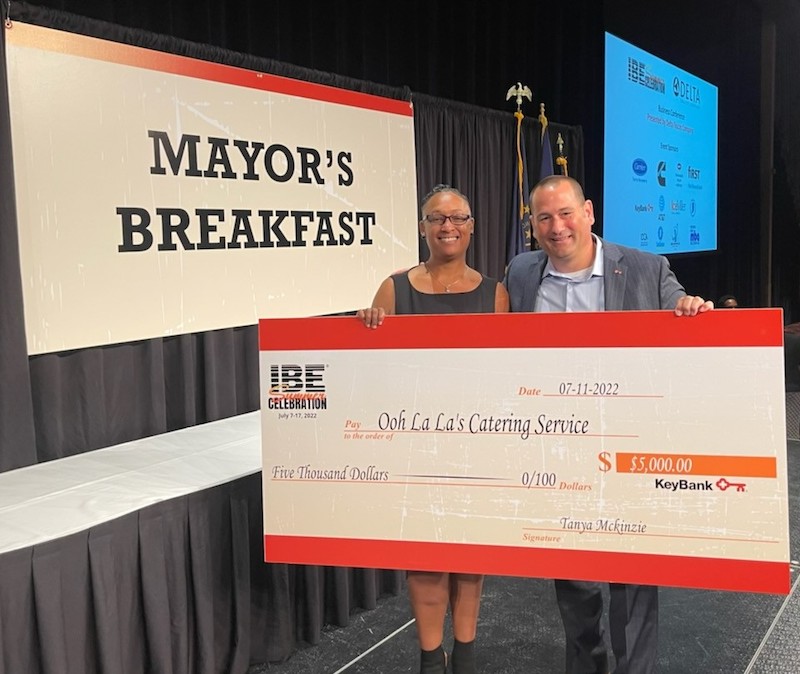 two people holding an oversized check