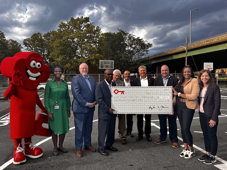 group with an oversized check and mascot