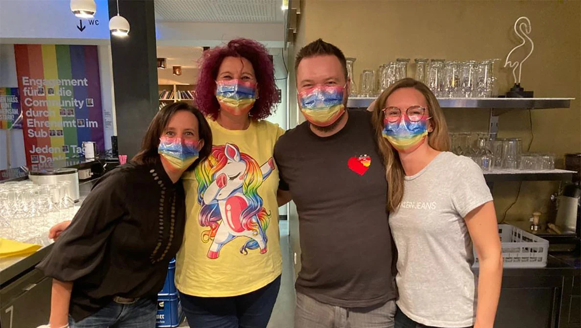 group of four people each wearing a rainbow mask