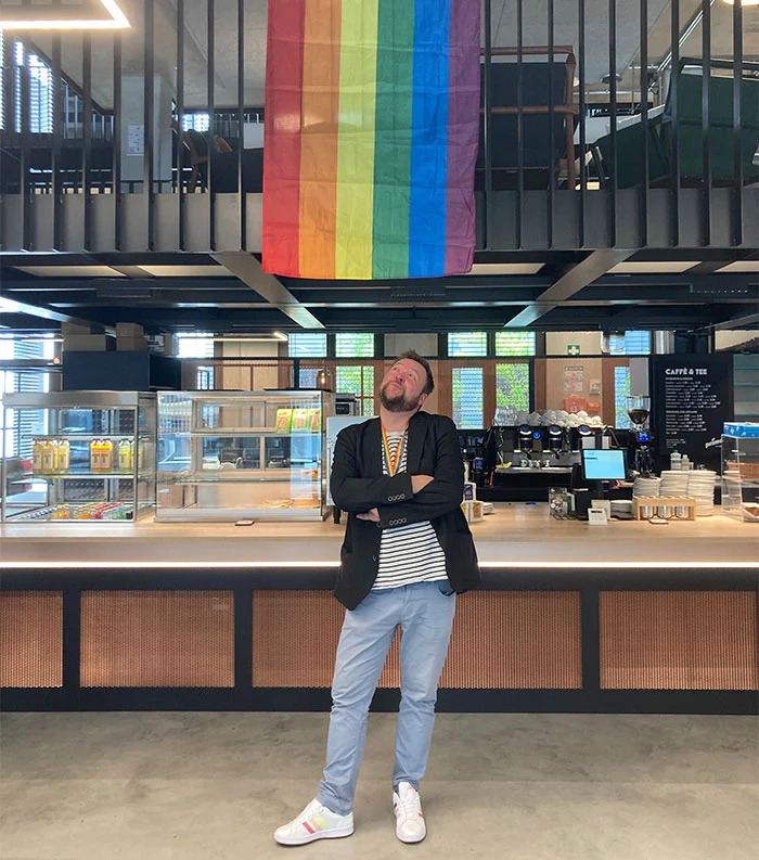 Lutz in a cafeteria, under a rainbow pride flag
