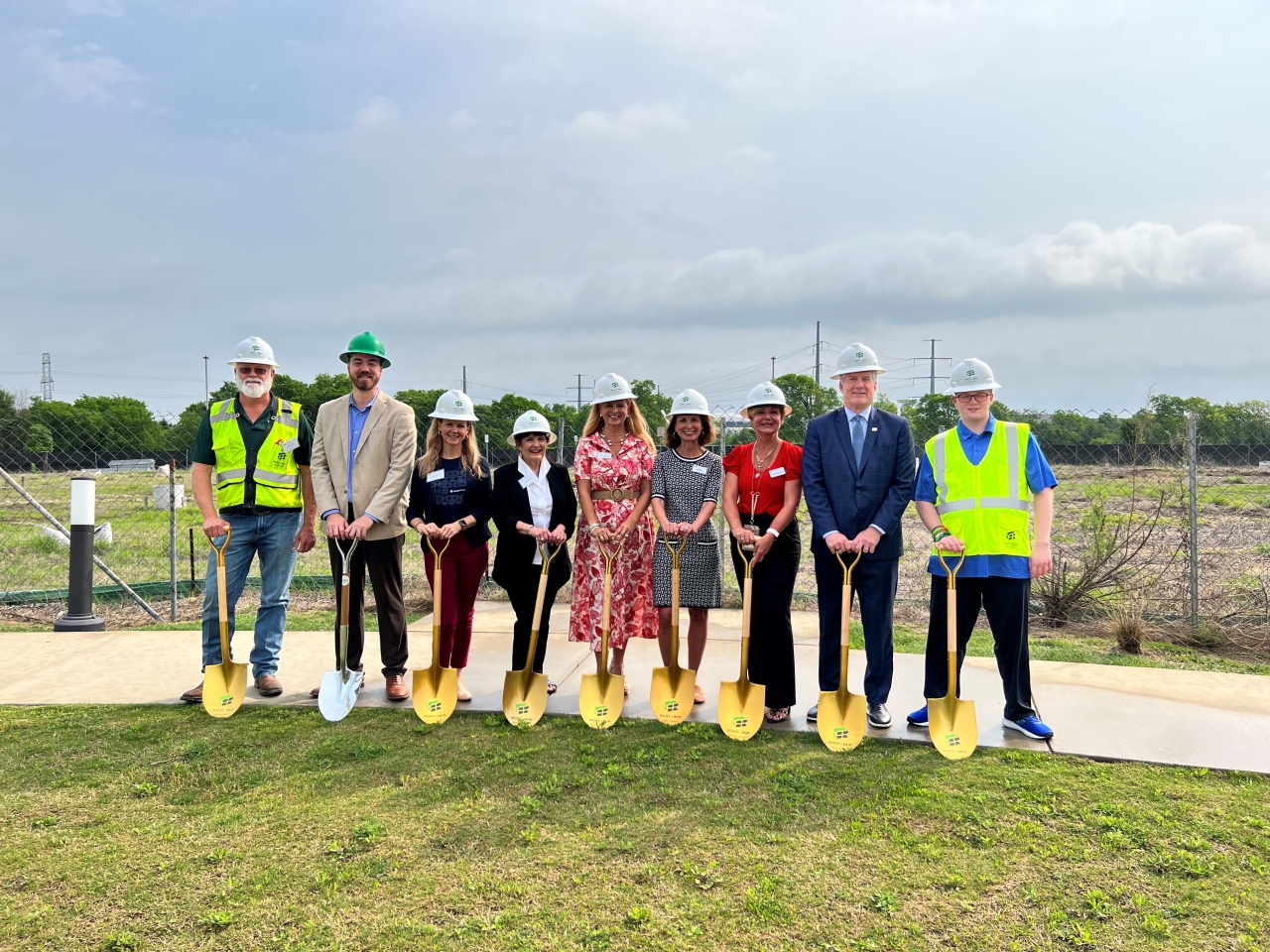 9 people with hardhats and shovels at a ground breaking event