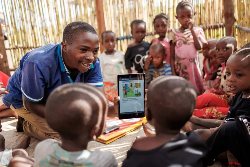 children being shown a tablet screen